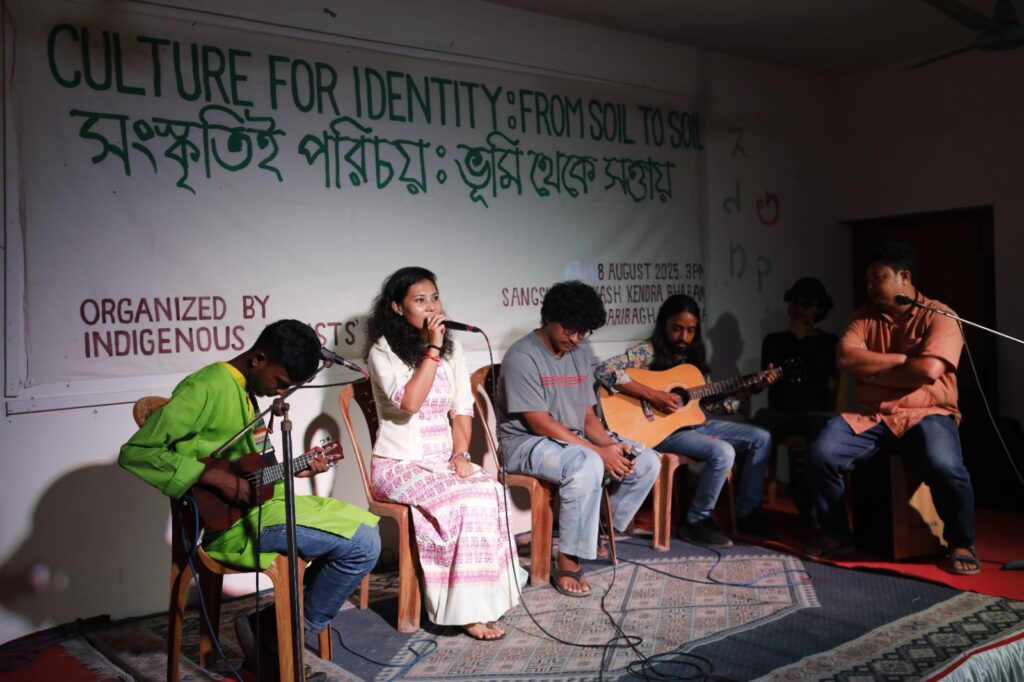 গান পরিবেশন করছেন আদিবাসী শিল্পীরা 